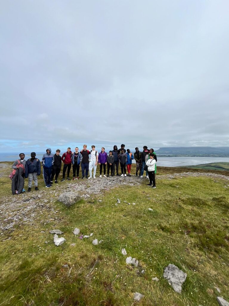 Group of young people at the top of a mountain in Sligo with scenic views in the background